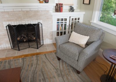 gray chair near fireplace with builtin cabinets