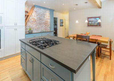 Dekton countertops kitchen island, table, and exposed brick